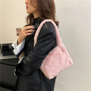 Close-up of pink faux fur shoulder bag worn by model in a modern office setting