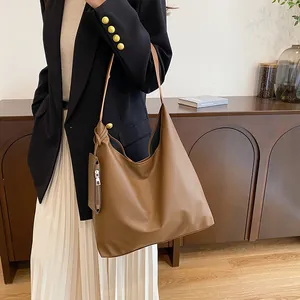 Detail of a large brown leather hobo bag with a matching small coin purse for daily commute