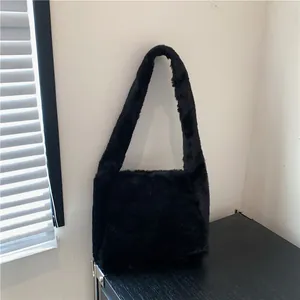 Close-up of a soft black plush faux fur tote bag with a minimalist shoulder strap