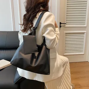 Detail of minimalist black PU leather tote bag with knotted strap and small coin purse