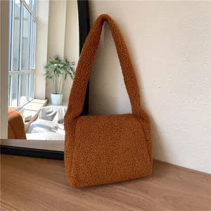 Close-up of caramel plush teddy fleece texture and flap structure on this chic shoulder bag