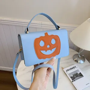 Λεπτομέρεια γαλάζιας τσάντας Halloween με πορτοκαλί πρόσωπο κολοκύθας και χρυσά κουμπώματα