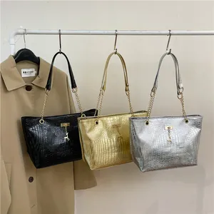 Detailed view of crocodile texture tote bags in black, gold, and silver with metal deer charms