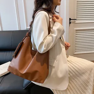 Brown PU leather tote bag shown on shoulder with detachable small coin purse detail