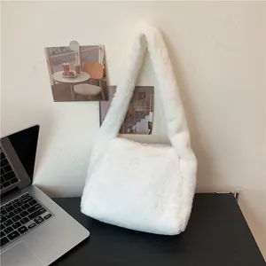 Detail shot of the plush white faux fur texture on a soft minimalist underarm bag