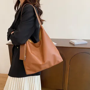 Detailed macro view of brown faux leather tote with functional side zipper pouch