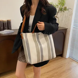 Vue détaillée du sac cabas en toile rayée avec bandoulière réglable en cuir marron