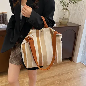 Détail du grand sac cabas en toile à rayures verticales avec poignées en tissu marron