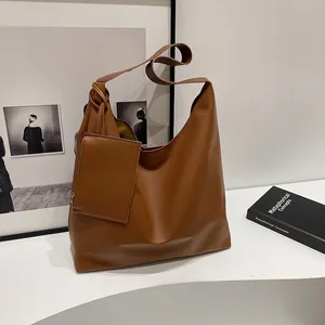 Detail view of large caramel faux leather tote bag with matching zipper coin pouch