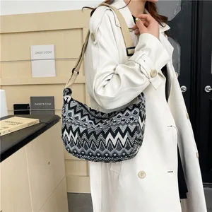 Dettaglio borsa a tracolla in tela chevron con tracolla larga su cappotto chic