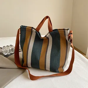 Détail du sac cabas en toile rayée avec bandoulière orange réglable et amovible