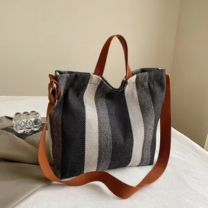 Détail du sac cabas en toile à rayures verticales avec texture tissée et bandoulière