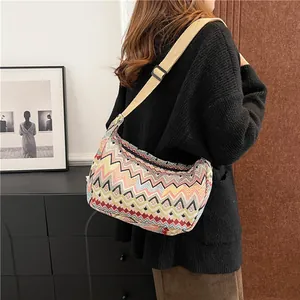 Dettaglio del motivo a zig-zag colorato e della tracolla beige regolabile della borsa