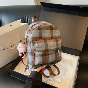 Detail of plaid wool mini backpack with plush pink charm and faux leather straps
