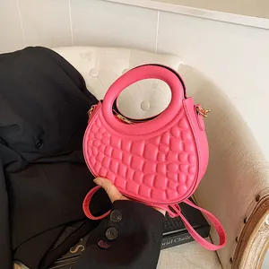 Detail of pink crescent bag with square embossing and golden metal zipper hardware