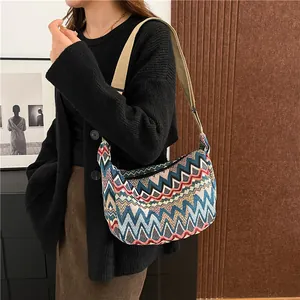 Dettaglio borsa a tracolla intrecciata colorata con ampia tracolla e motivo a zigzag