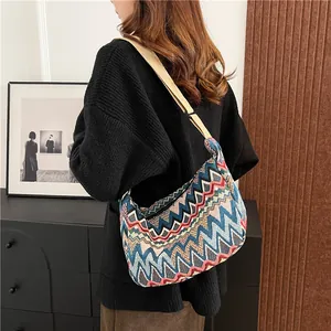 Vista laterale dettagliata della borsa a tracolla boho in tela con motivi geometrici colorati