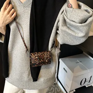 On-body view of a mini leopard print crossbody bag with vintage buckle details