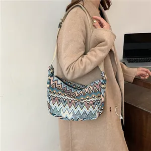 Dettaglio borsa a tracolla in tela boho con motivo geometrico retrò indossata a spalla