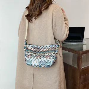 Dettaglio borsa a tracolla etnica tessuta con motivi geometrici e tracolla larga