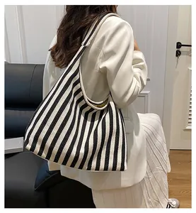 Grand sac cabas en toile à rayures verticales porté dans une scène de vie réelle