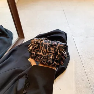 Detailed view of women's leopard print mini square bag with black buckle accents