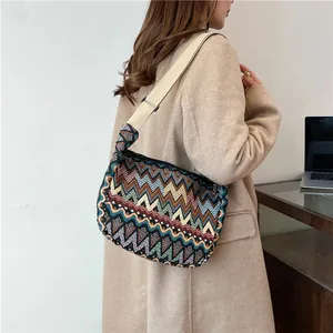 Dettaglio di borsa a tracolla intrecciata geometrica colorata con cinturino in tela