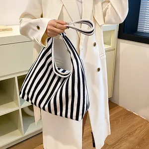 Détail d'un grand sac cabas en toile à rayures verticales avec de larges anses