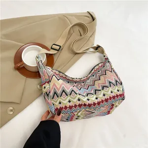 Dettaglio borsa a tracolla in tela con motivo etnico colorato, cinturino e zip
