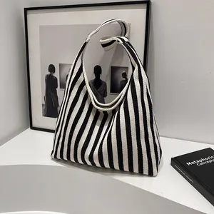 Vue détaillée du sac cabas en toile rayée avec arrière-plan artistique minimaliste