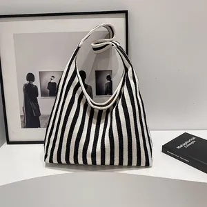Texture détaillée d'un sac cabas en toile à rayures verticales noires et blanches chic