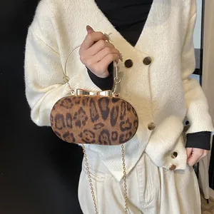 Dettaglio borsa da sera leopardata con chiusura a fiocco dorato e manico rotondo