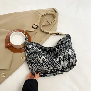 Dettaglio della trama a onde tessuta su una borsa a tracolla in tela a forma di mezzaluna