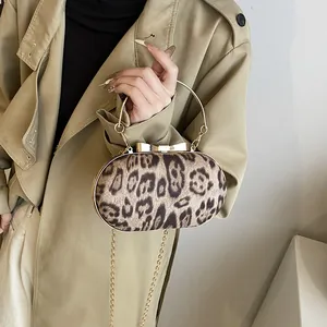 Dettaglio della borsa leopardata in ecopelliccia con manico ad anello dorato e catena