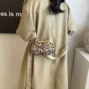 Dettaglio borsa leopardata con chiusura a fiocco dorato e tracolla a catena metallica