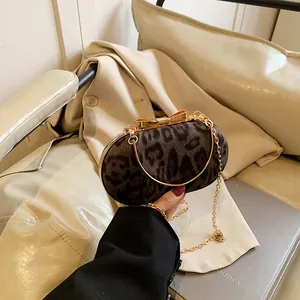 Dettaglio della pochette leopardata con chiusura a fiocco dorato e tracolla a catena