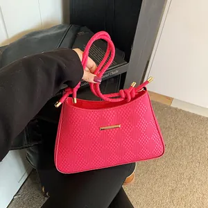 Fashionable rose red woven handbag with gold hardware and stylish knotted handle design