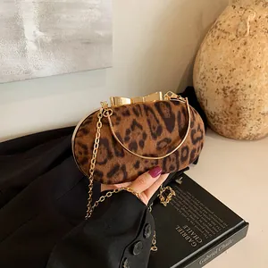 Dettaglio della pochette leopardata con chiusura a fiocco dorato e catenella