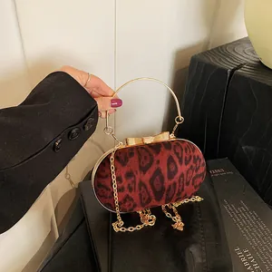 Dettaglio borsa box leopardata rossa con chiusura a farfalla dorata e manico