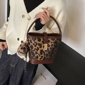 Detail der Bucket Bag mit Leopardenmuster, goldenem Drehverschluss und flauschigem Anhänger