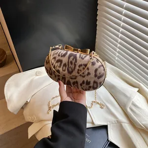 Dettaglio della borsa leopardata con chiusura a fiocco dorato e tracolla a catena