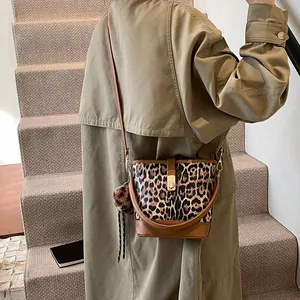 Detailansicht der Leopard-Eimertasche mit Plüsch-Anhänger und braunem Lederriemen