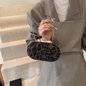 Borsa a scatola leopardata con manico ad anello dorato e chiusura a fiocco su blazer