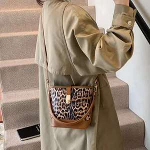 Nahaufnahme der Leopard-Eimer-Umhängetasche mit braunem Rand und goldenem Metallverschluss