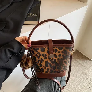 Detailansicht der Beuteltasche mit Leopardenmuster, braunem Lederbesatz und Schloss