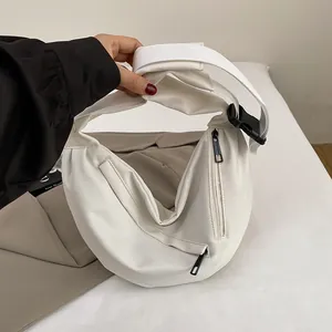 Detail of white nylon crescent bag with contrast black zippers and wide shoulder strap