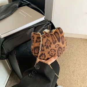Detail einer Katzen-Abendtasche mit Leopardenmuster, Kristallverschluss und Goldkette