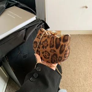 Detail der Leoparden-Samttextur und des Kristallverschlusses an der goldfarbenen Tasche