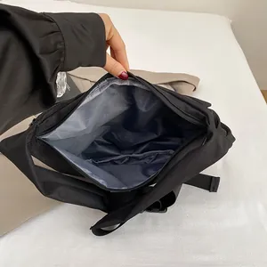 Minimalist black canvas dumpling bag with organized internal zipper pocket and inner slot