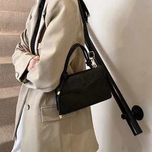 Chic black crossbody bag with embossed koi and lotus patterns on a premium PU leather finish